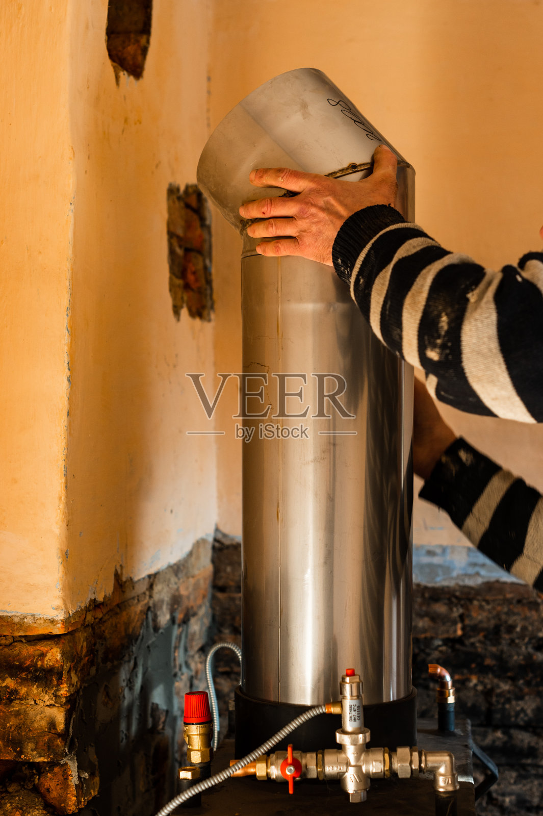 烟囱为壁炉，在壁炉上方安装一根管道到烟囱，在房子里进行维修工作。照片摄影图片