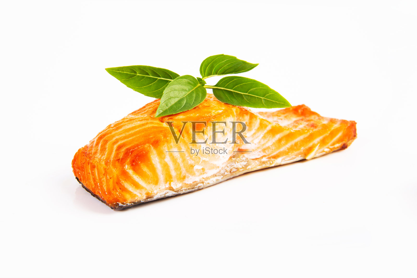 一块新鲜的烤鳟鱼与罗勒小枝在白色的背景照片摄影图片