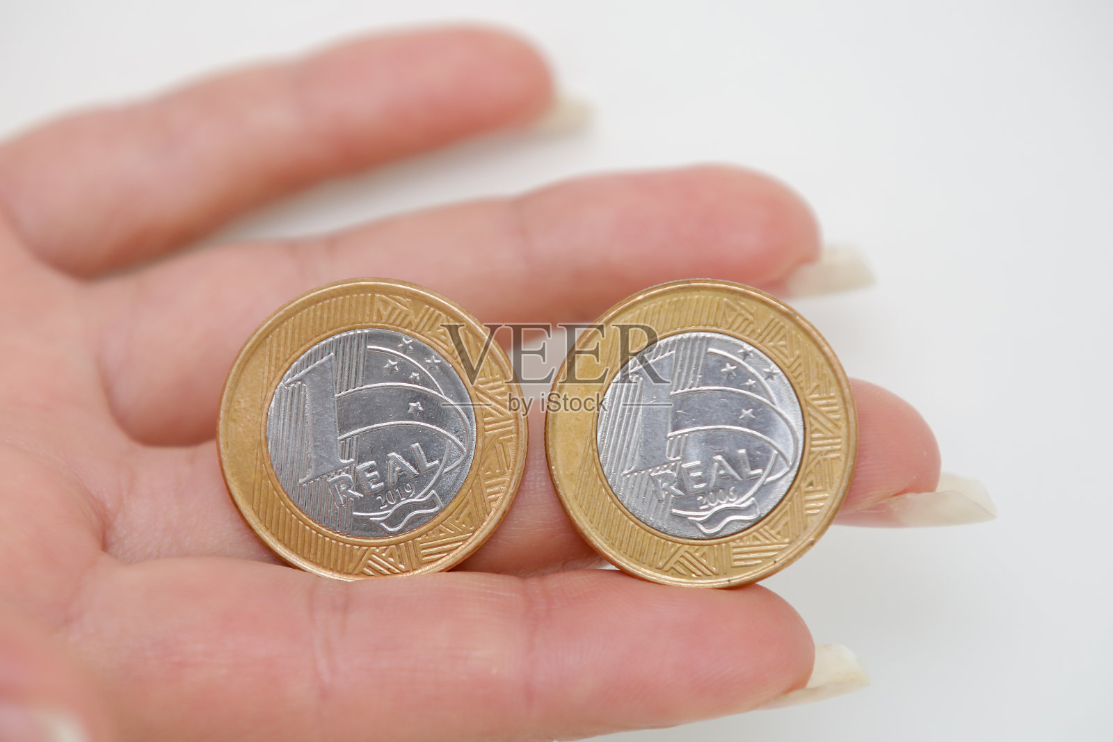 巴西1女人手里的真硬币。照片摄影图片