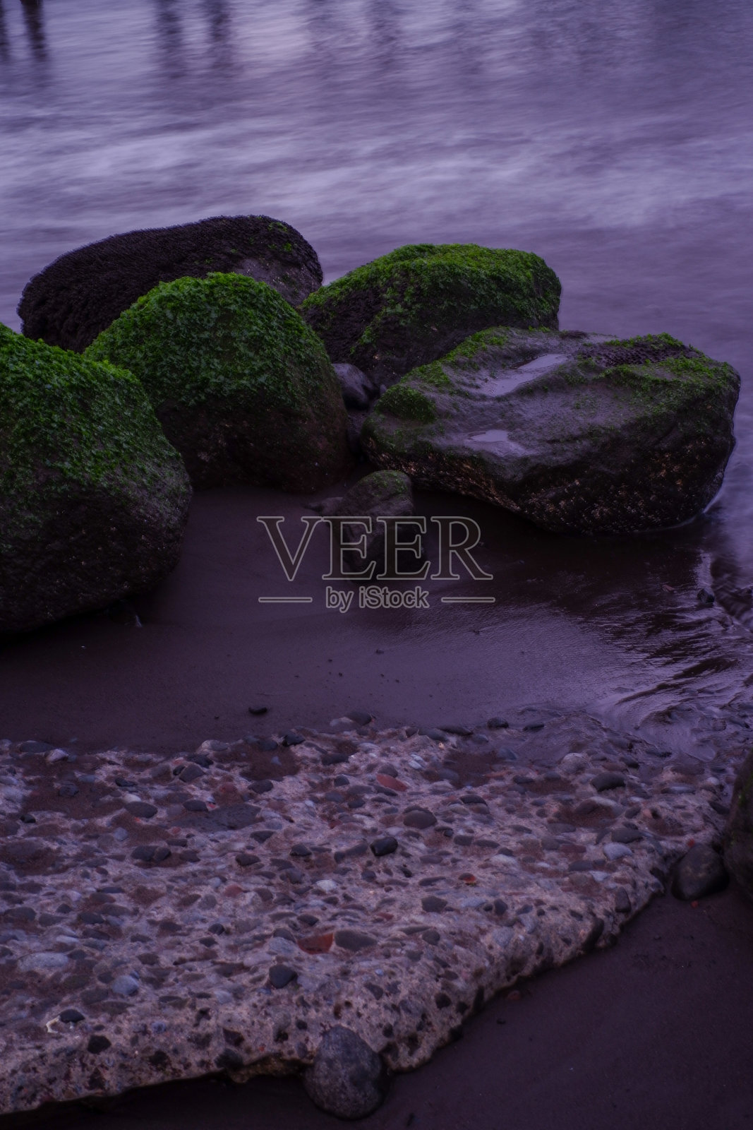 海滩上的珊瑚和岩石与柔和的白色海浪相结合。照片摄影图片