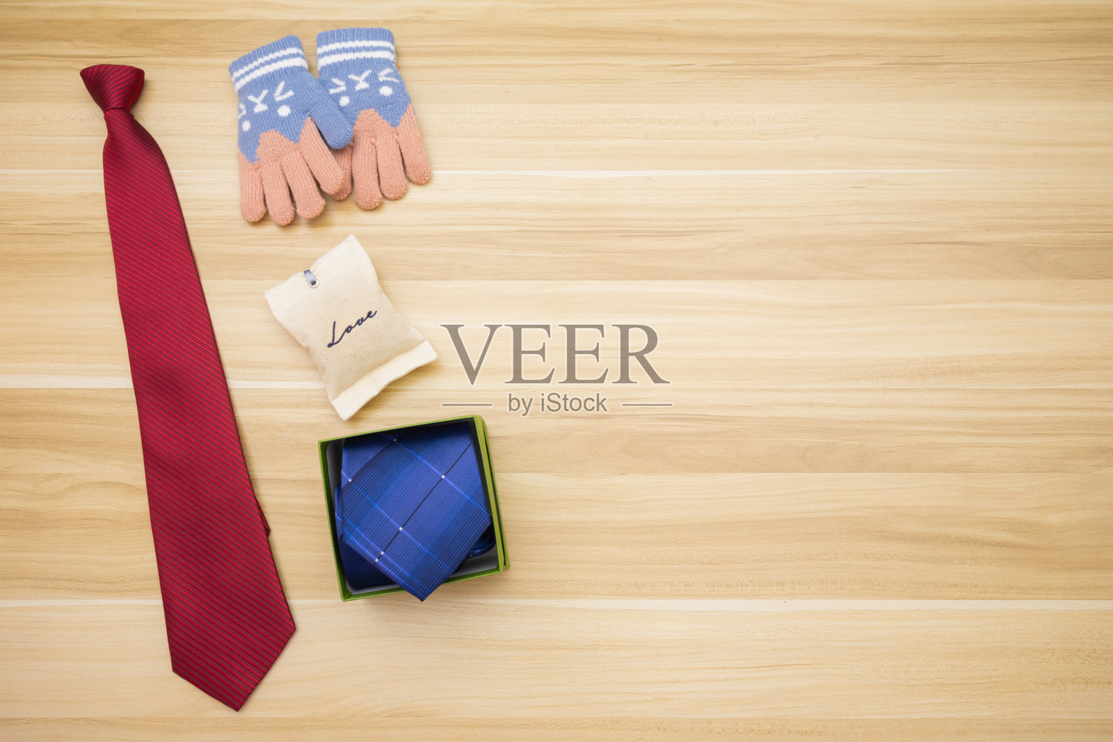 以无品牌手套代表女儿的场景在上面送给父亲蓝色的领带盒子，红色的领带和木制背景的爱包照片摄影图片
