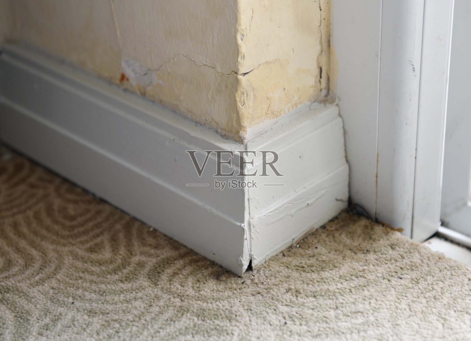 旅馆里旧的白色底座和地毯。在角落里成型。内部细节。照片摄影图片