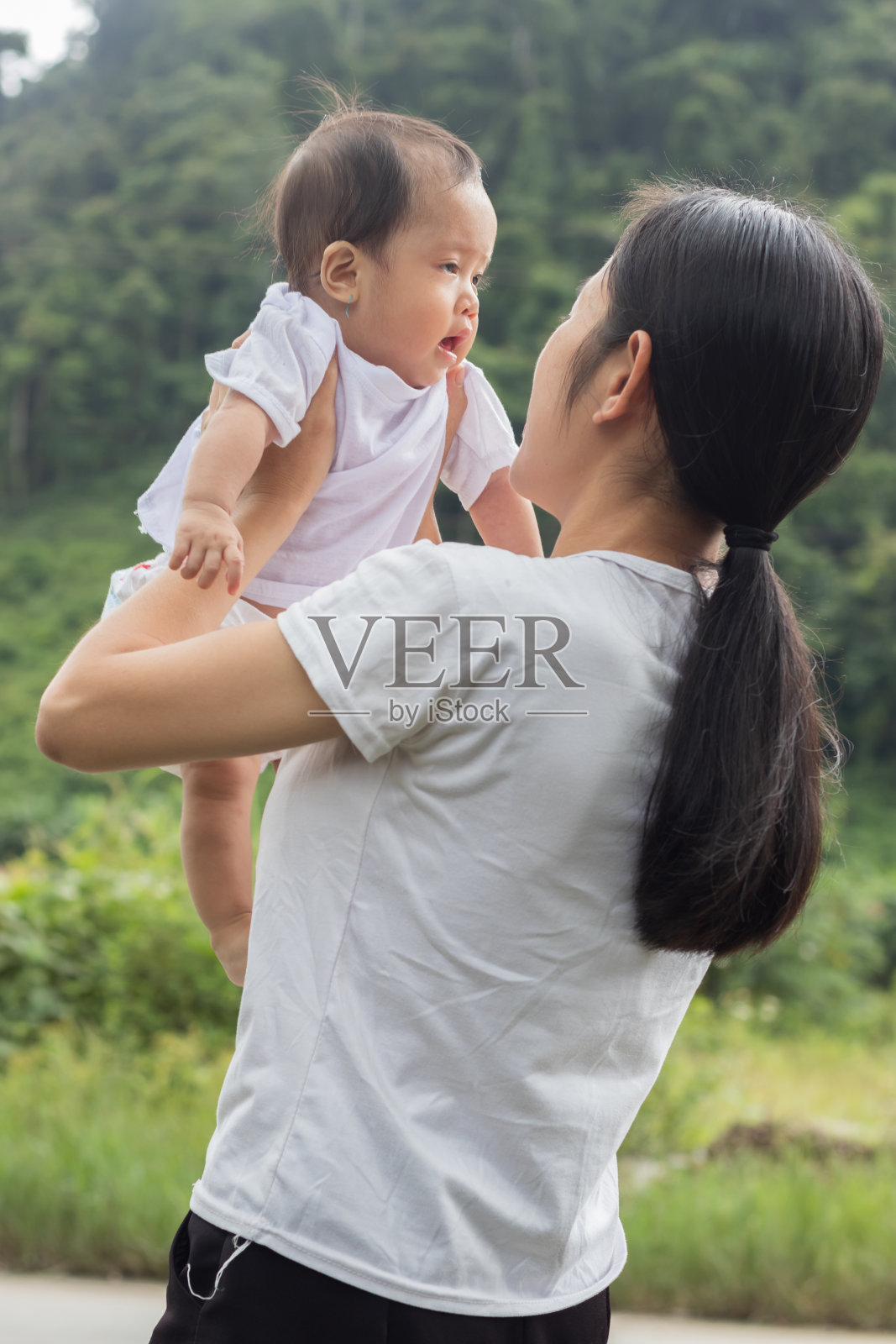 漂亮的亚洲女人怀里抱着一个小女孩照片摄影图片