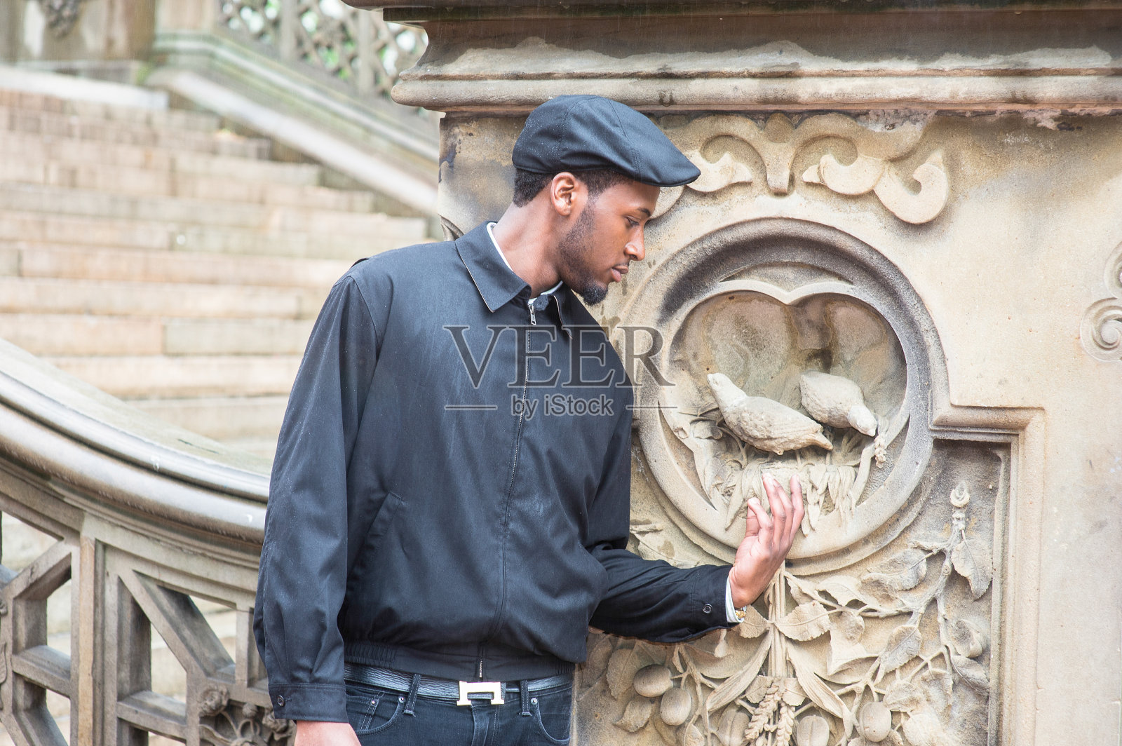 一个年轻的黑人在下雨天站在纽约的公园里思考着照片摄影图片