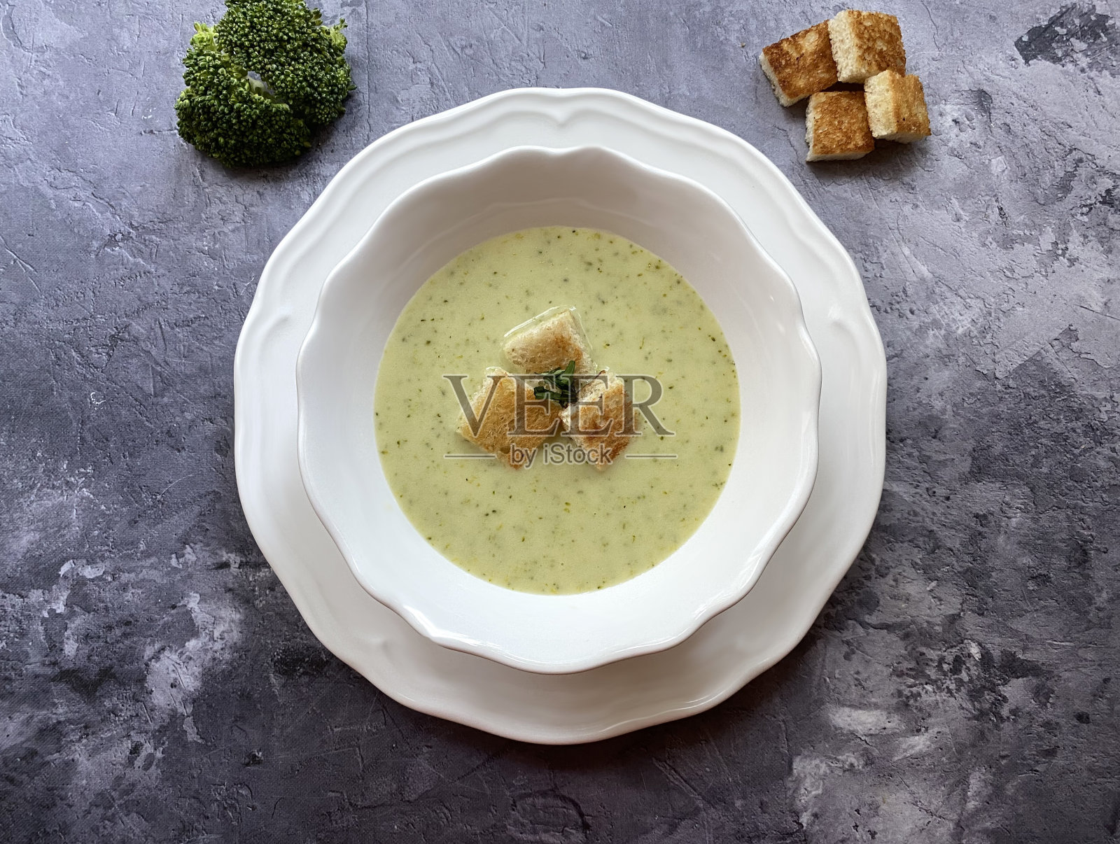 蔬菜花椰菜奶油汤配面包块。照片摄影图片