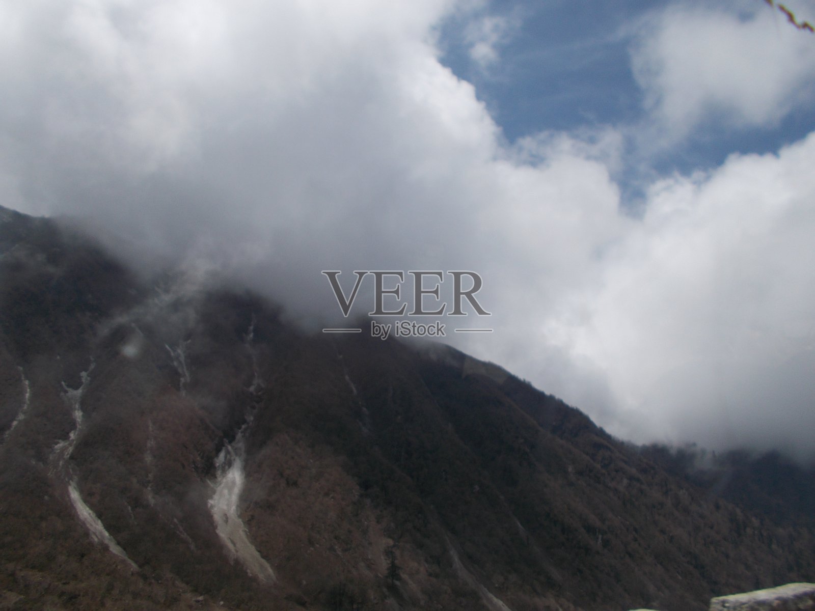 锡金的甘托克山。山和路被雾、雪和云所覆盖。照片摄影图片