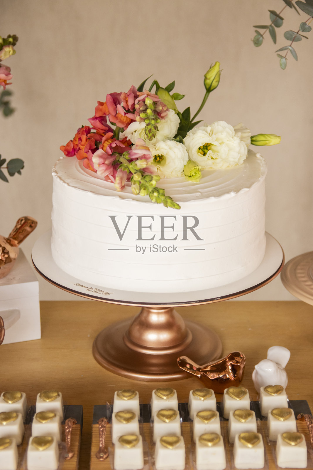 婚礼的设置。蛋糕桌上摆满了糖果、装饰品和鲜花照片摄影图片