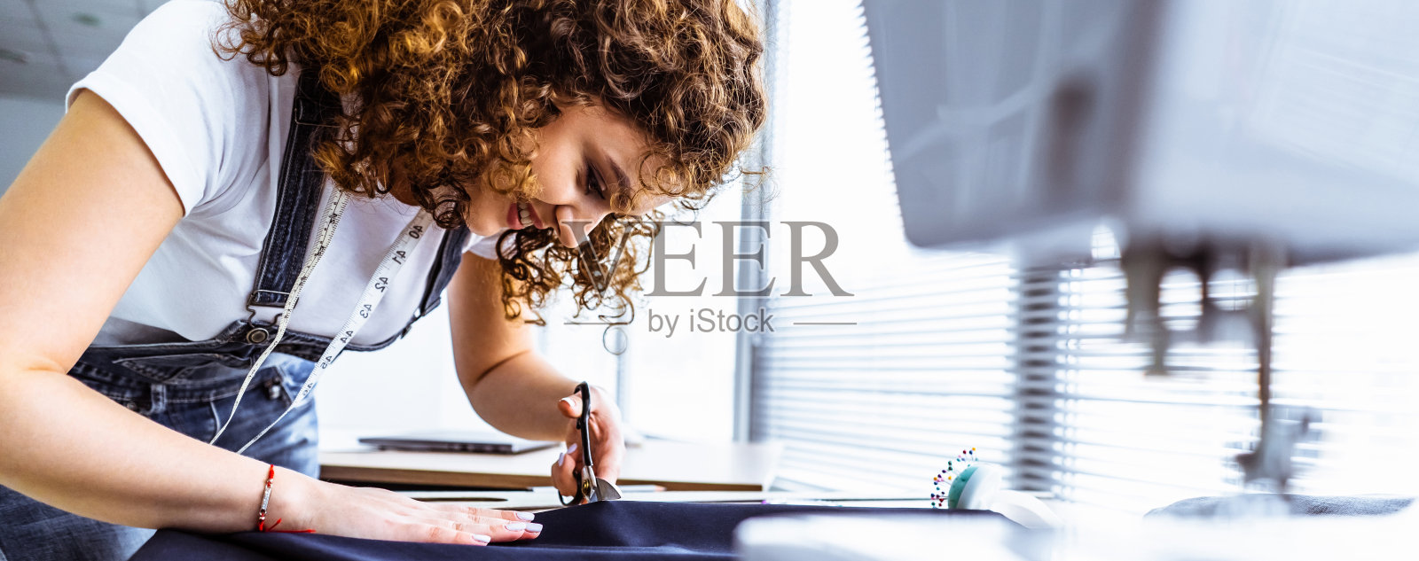 漂亮的裁缝在桌子上工作照片摄影图片