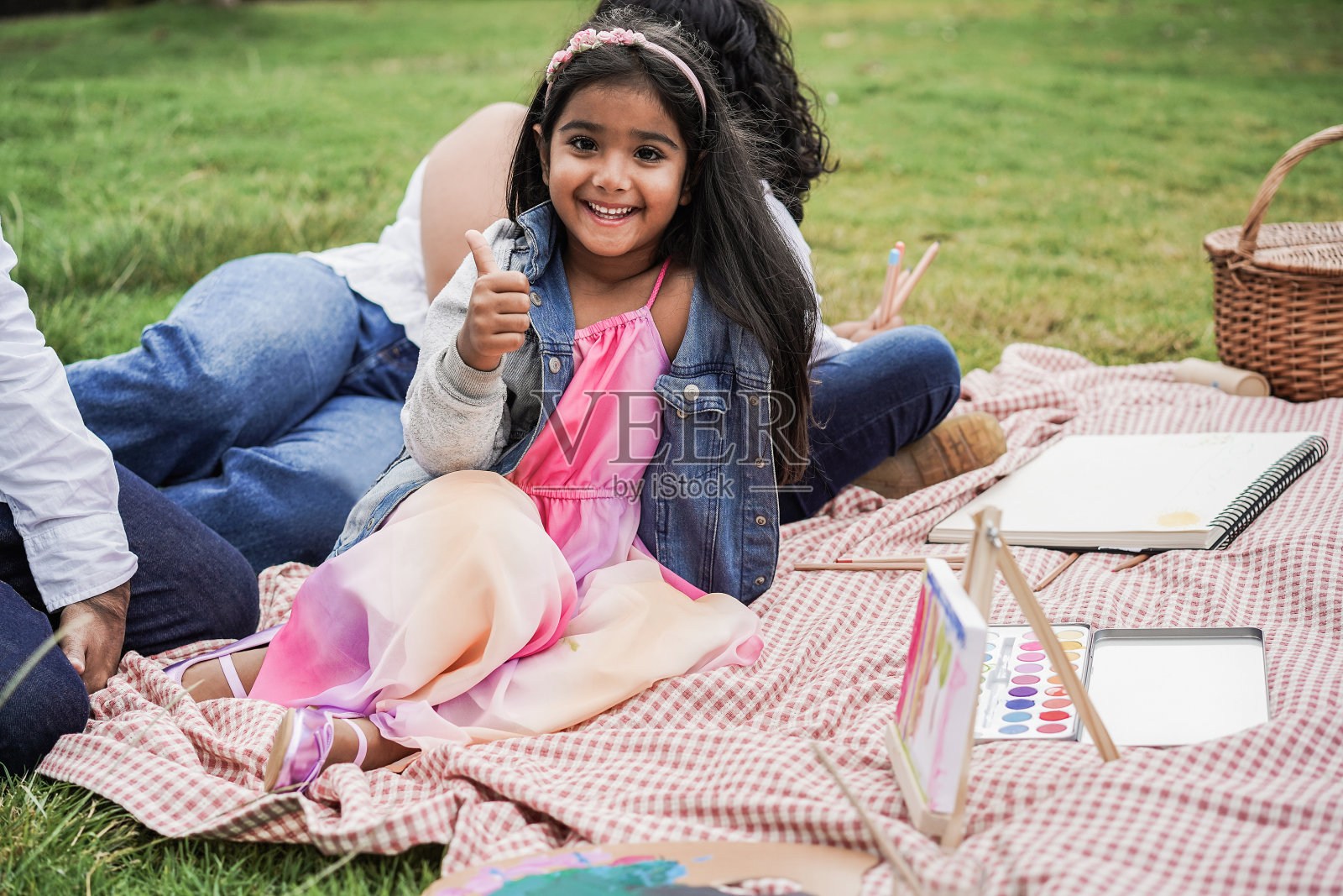 快乐的印度家庭和孩子们在城市公园户外画画-主要关注女孩的脸照片摄影图片