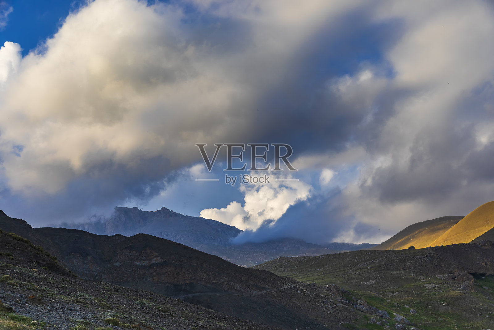 来自太阳的光线穿过云层进入了山脉照片摄影图片