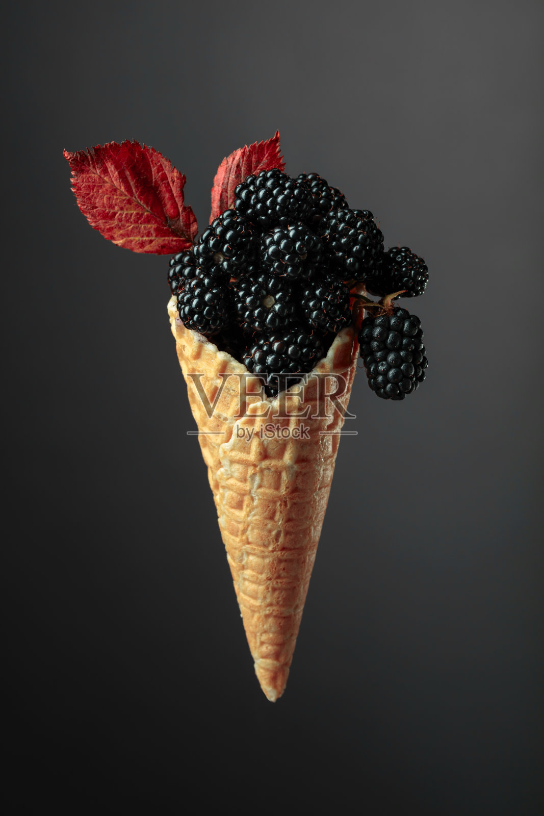 新鲜的黑莓放在华夫饼蛋筒里。照片摄影图片