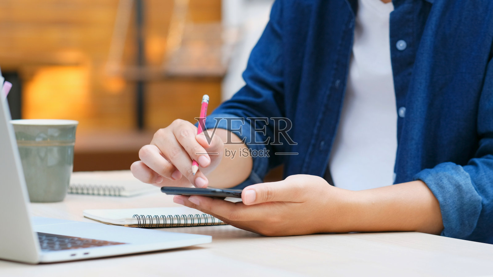 在线学习，全手用手机进行数字家庭学习，成年男学生一边上课一边用智能手机学习，教育照片摄影图片