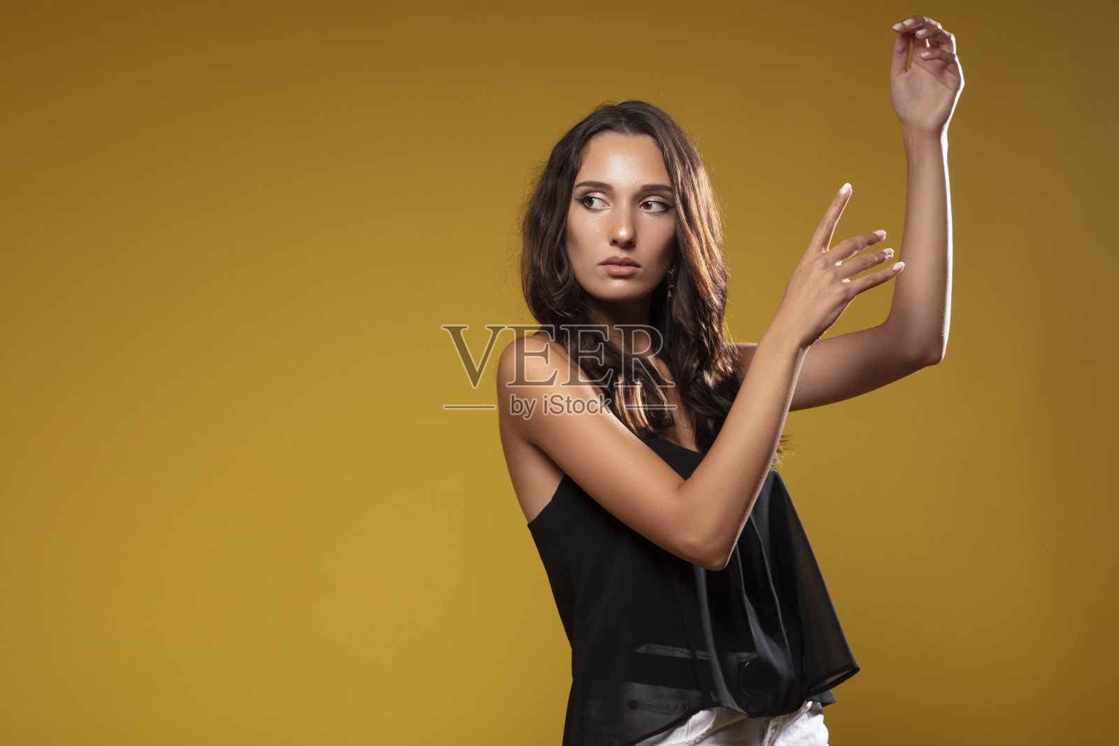 美丽的时尚女子在黄色背景下摆姿势照片摄影图片