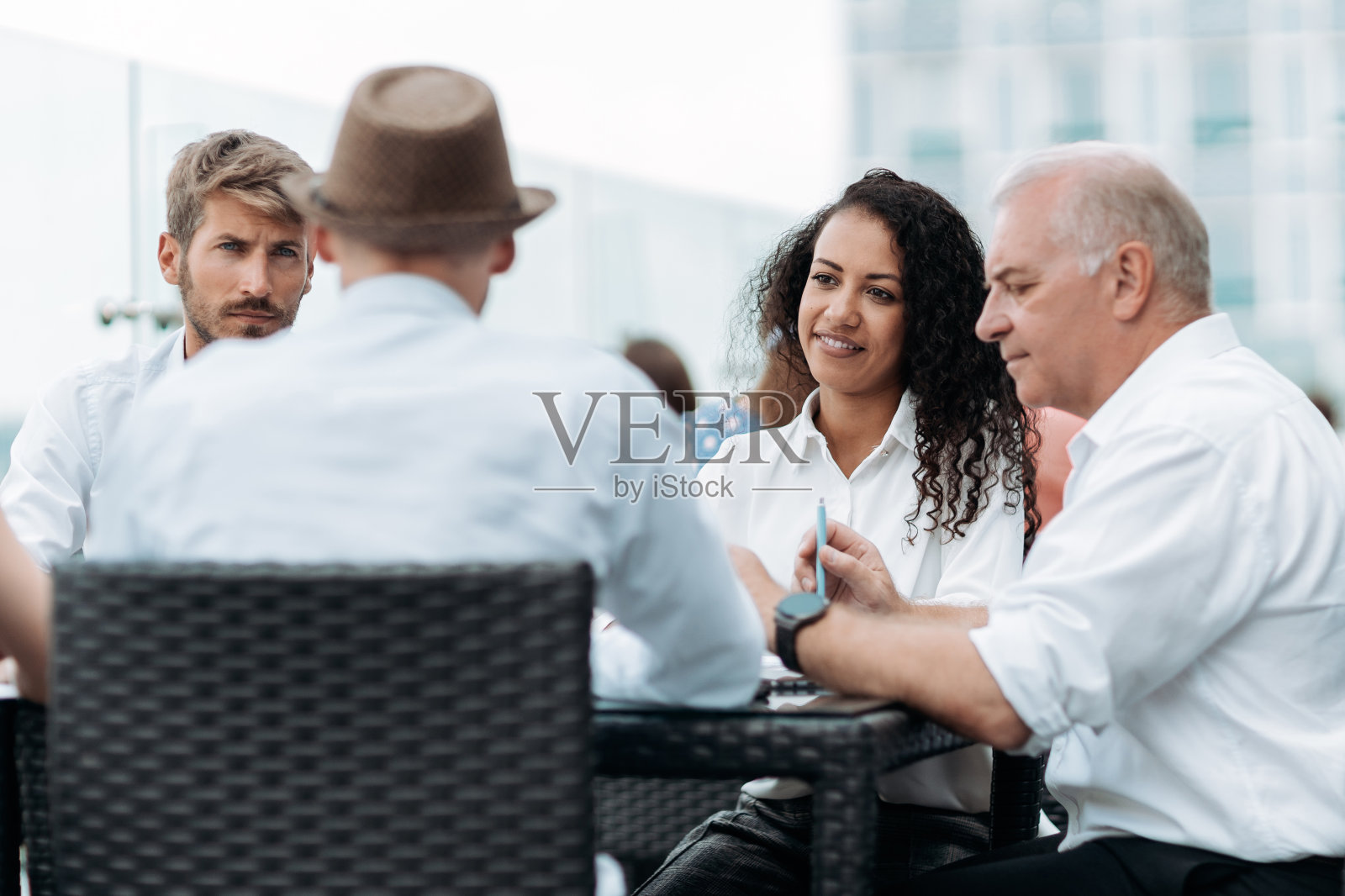 一群国际商务人士坐在讨论桌旁照片摄影图片