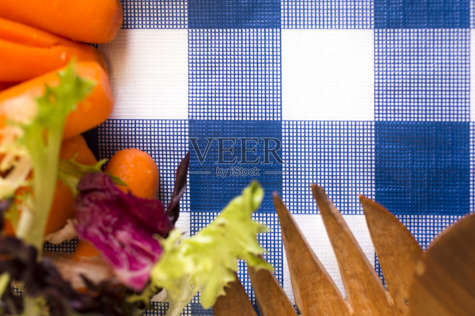 蓝色格子桌布上的蔬菜。照片摄影图片