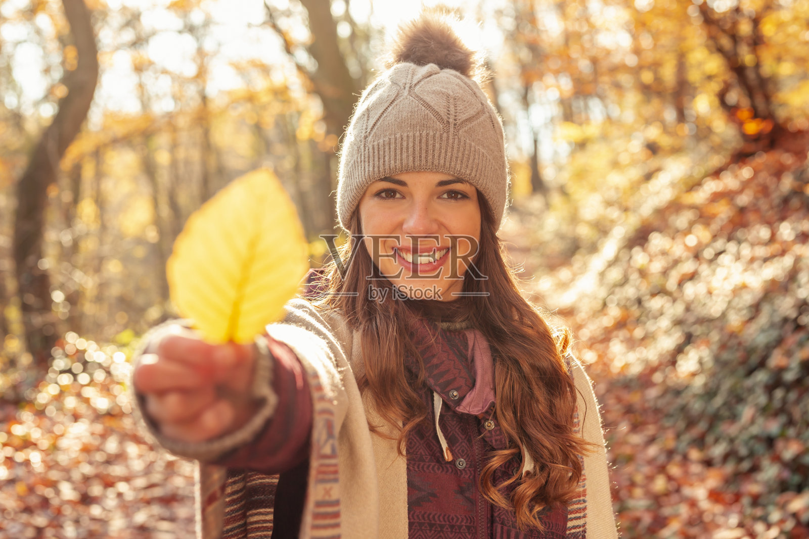 女人捧着秋天枯黄的落叶照片摄影图片