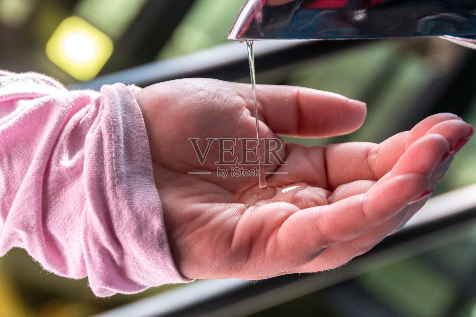 一个女人把酒精凝胶放在手上照片摄影图片