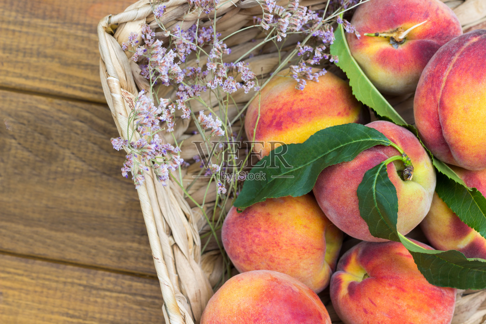 柳条筐里的绿叶熟桃照片摄影图片