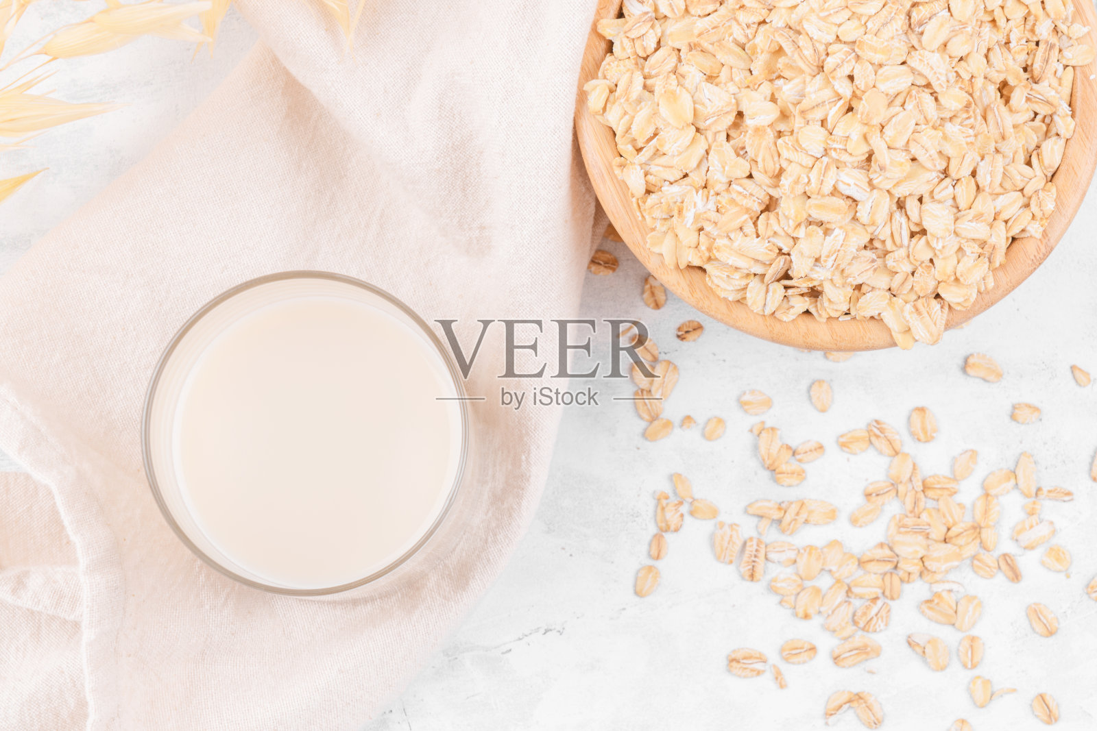 杯燕麦牛奶和碗燕麦片放在白石桌上，俯视图照片摄影图片