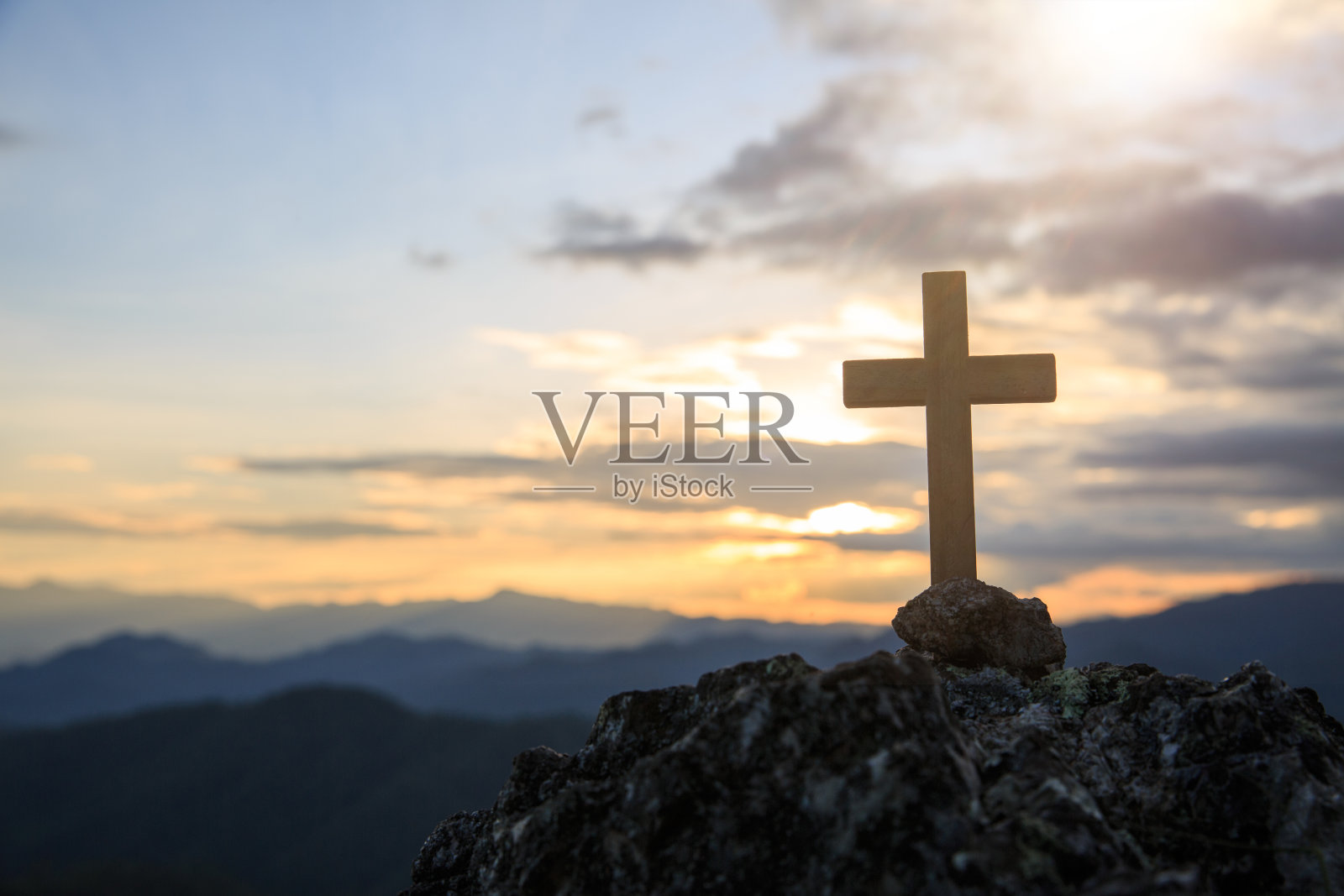 耶稣基督十字架：复活节概念，戏剧光照下的基督教木制十字架与彩色山景日落背景照片摄影图片