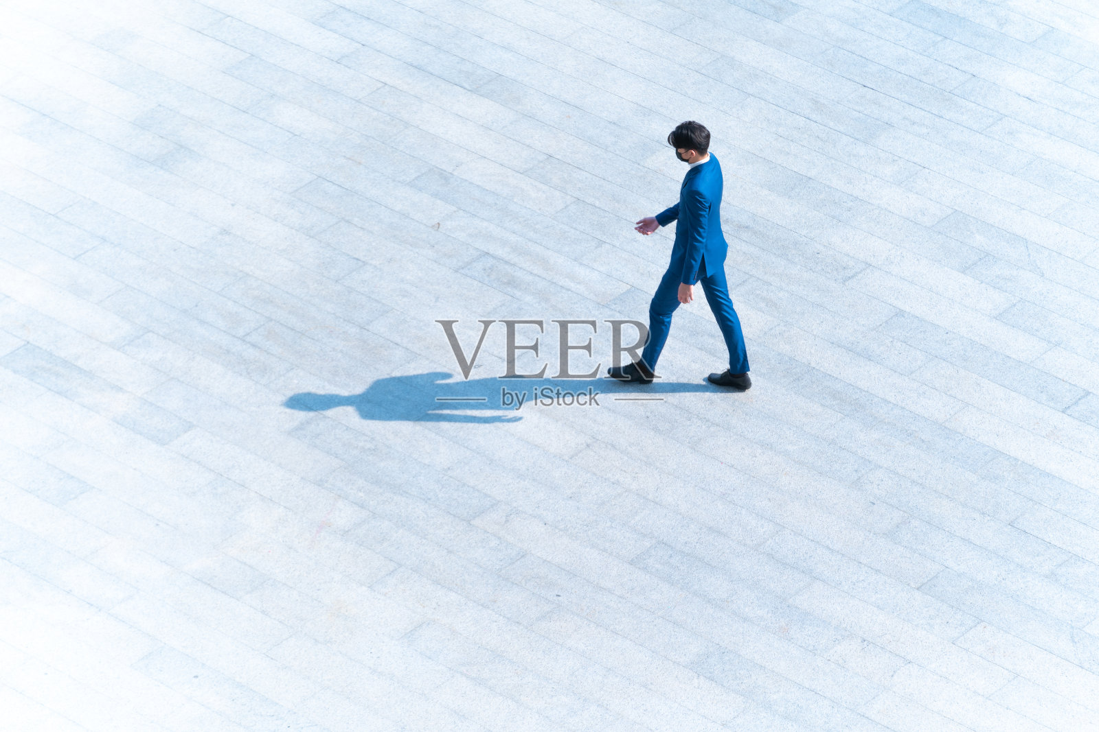 顶部鸟瞰商人们走在行人混凝土上，地面上有黑色的剪影，社会静物的概念。照片摄影图片