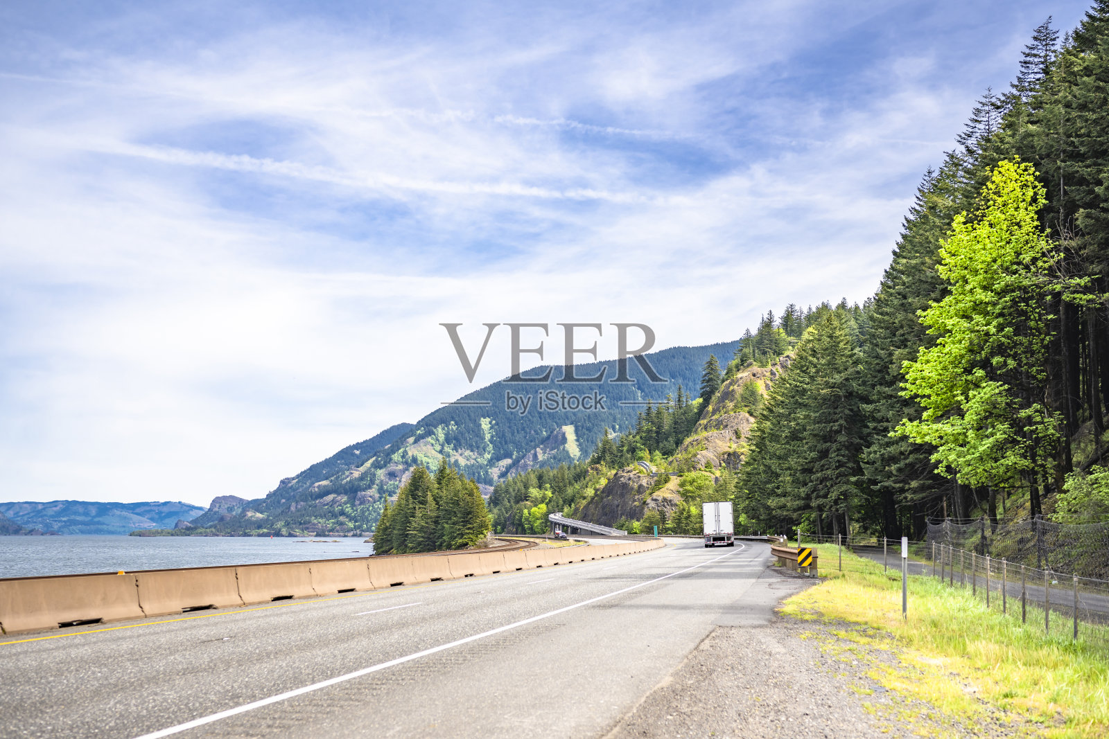 沿哥伦比亚河蜿蜒的高速公路上有大卡车半挂车和干货车半挂车，在哥伦比亚峡谷又有娱乐区来往照片摄影图片