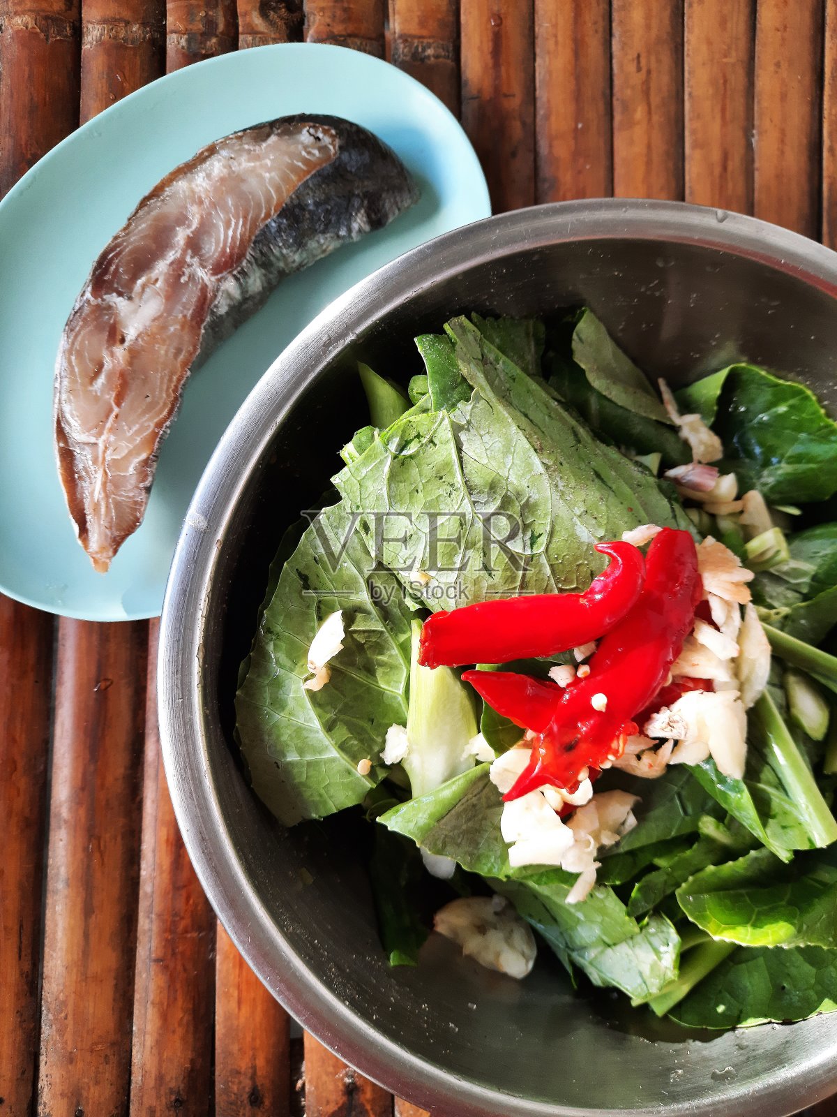 烹饪准备-炒甘蓝和干咸鱼与红辣椒。照片摄影图片