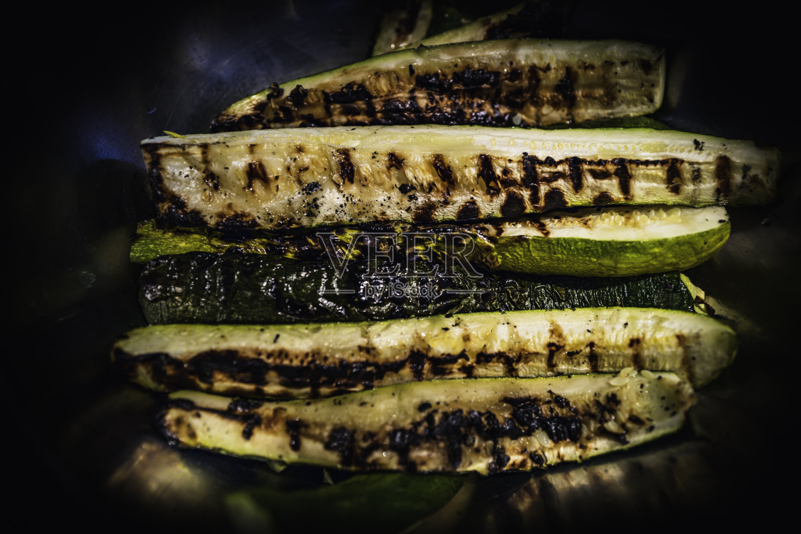 烤南瓜片放在深色的盘子里照片摄影图片