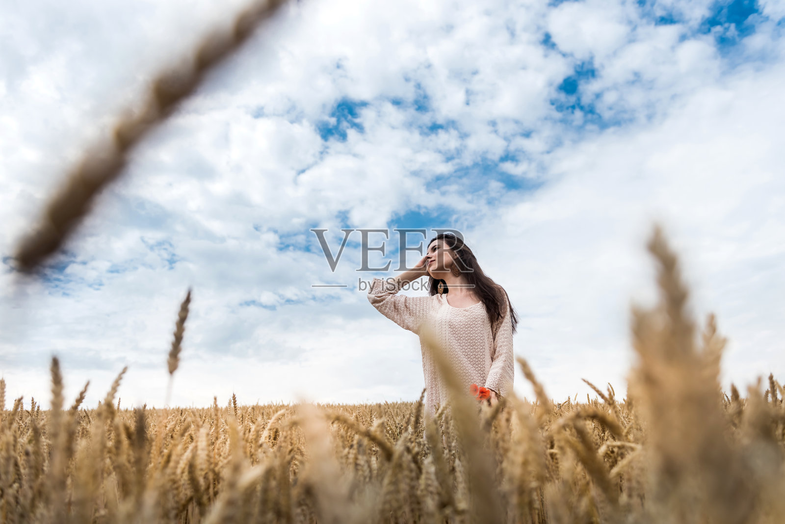 穿着夏装的年轻女子站在麦田里享受着生活照片摄影图片