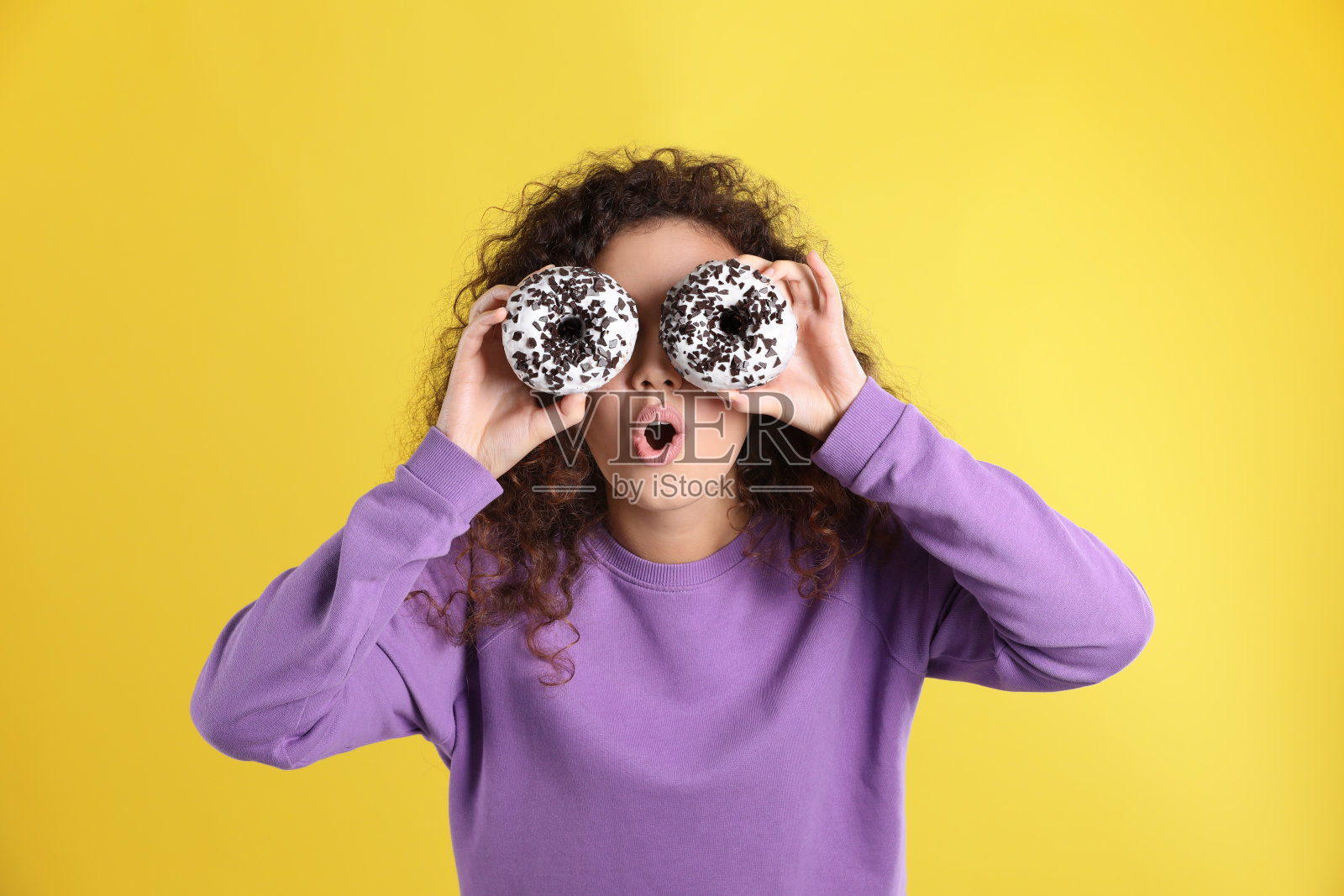 漂亮的非裔美国女人，黄色背景上有甜甜圈照片摄影图片