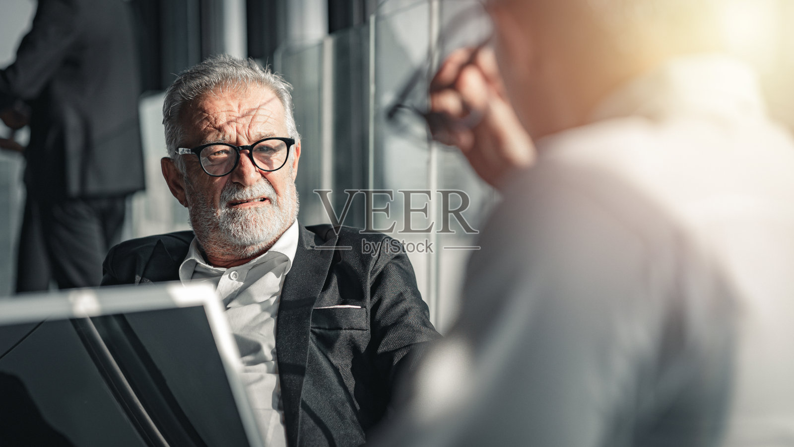 商人和他的同事交谈。照片摄影图片