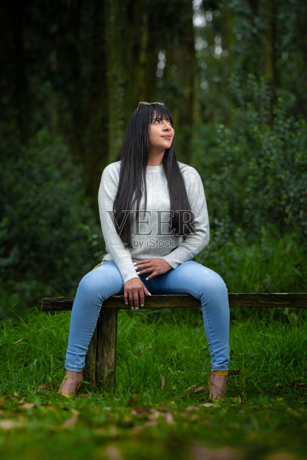 穿着随意的拉丁女孩坐在大自然的中间，放松的概念照片摄影图片