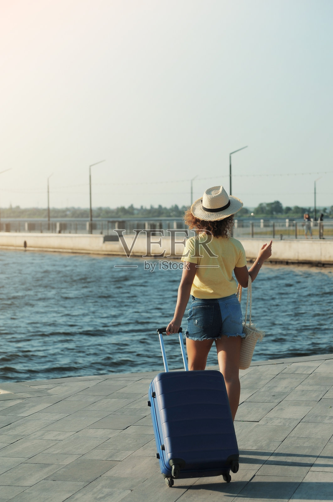 漂亮的年轻女人戴着帽子，拿着箱子照片摄影图片