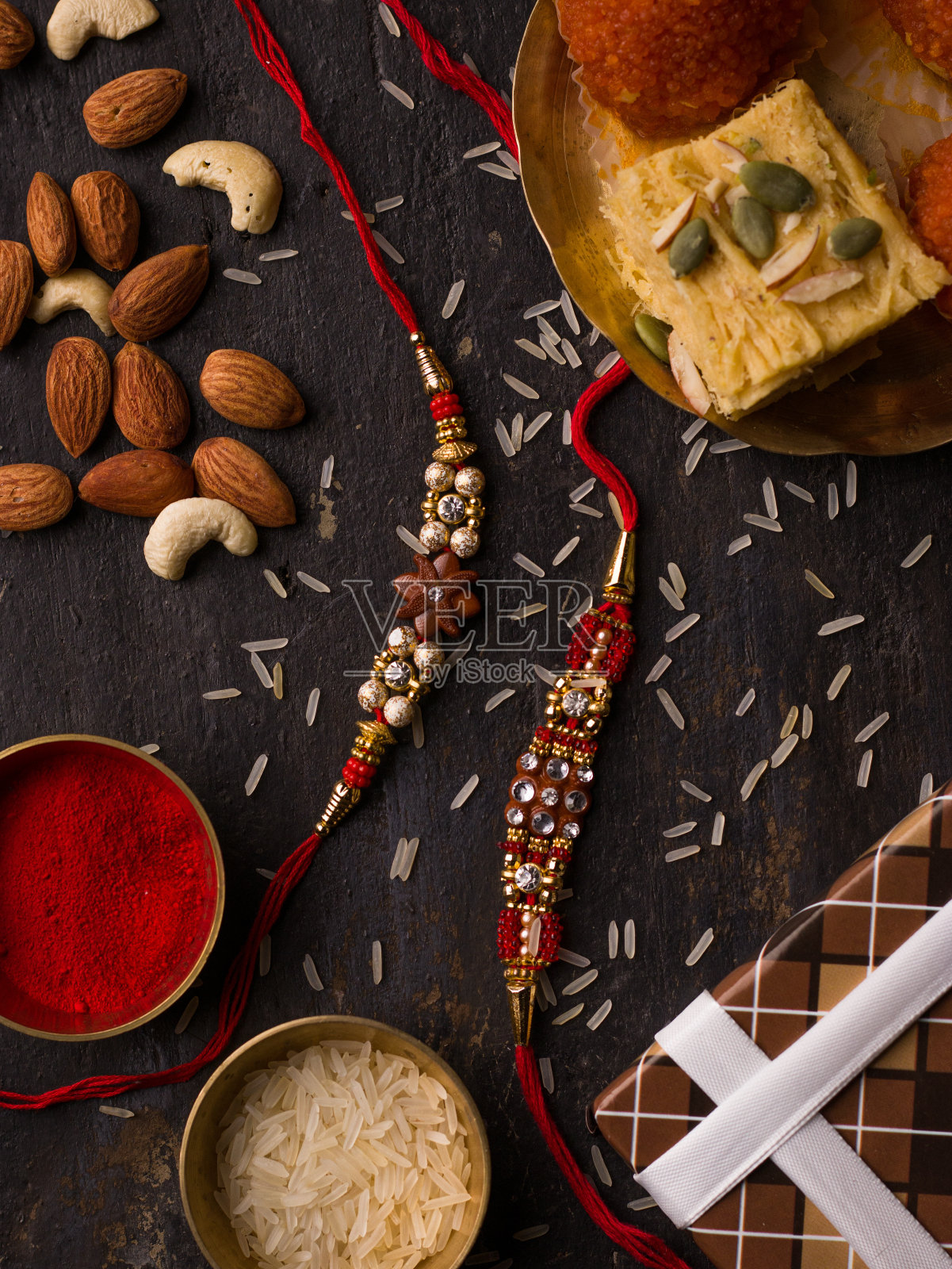 Raksha Bandhan背景与优雅的Rakhi和米粒深色纹理背景。照片摄影图片