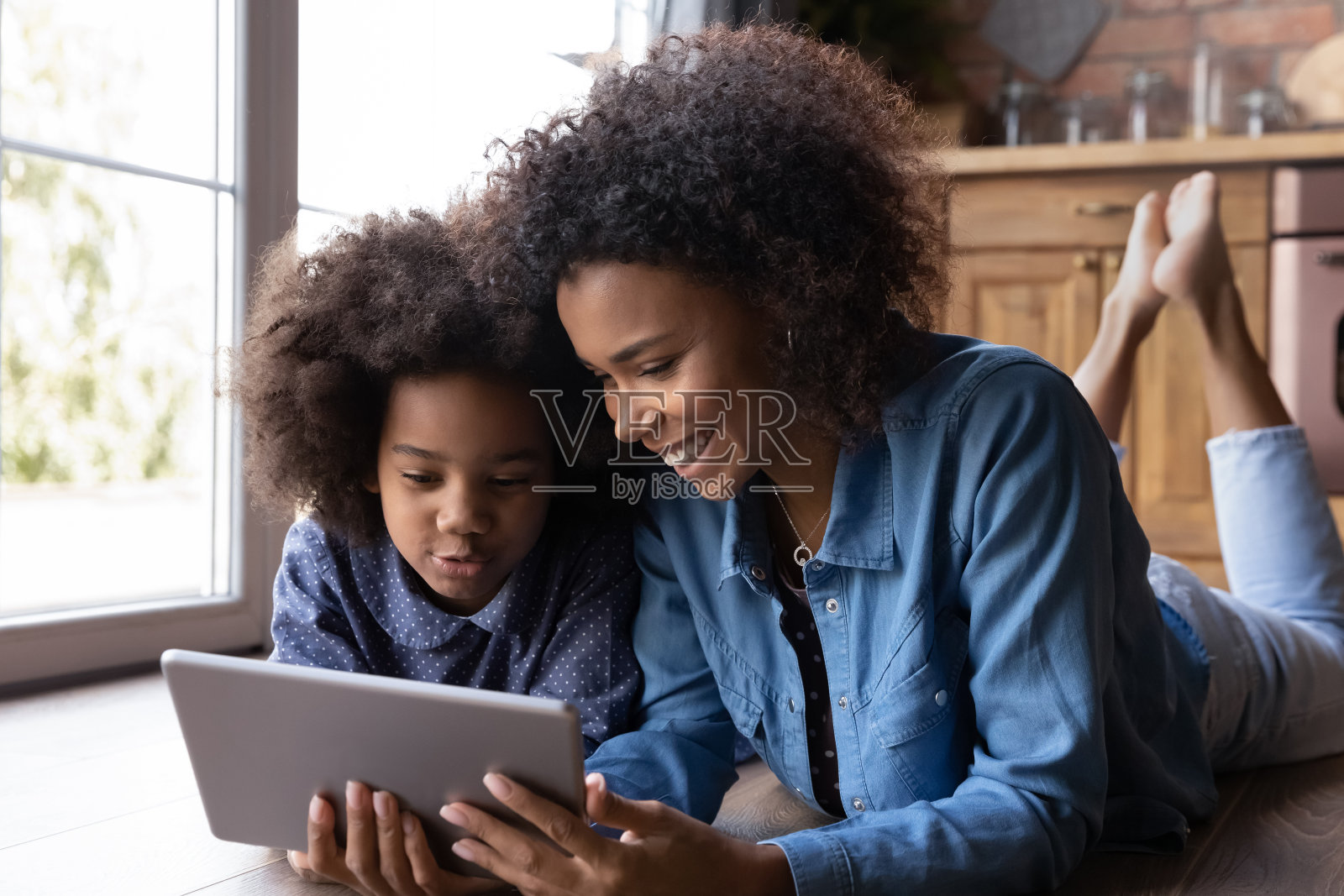 快乐的民族妈妈和女儿一起使用平板电脑照片摄影图片