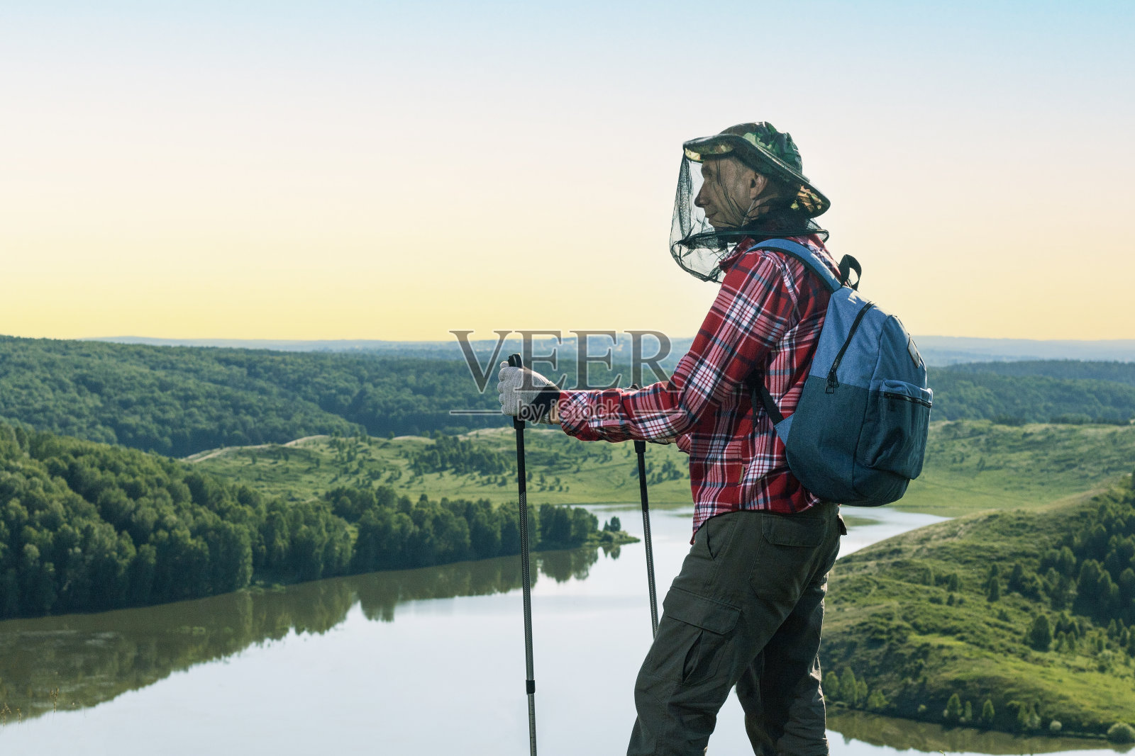 徒步旅行者在秋天的山脉。快乐旅行者带着蚊帐在徒步旅行中防蚊。防止吸血昆虫叮咬。照片摄影图片