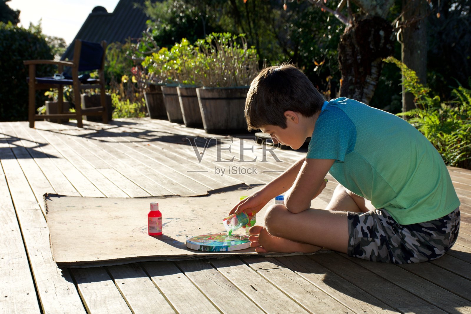男孩在圆形画布上制作大理石效果画照片摄影图片