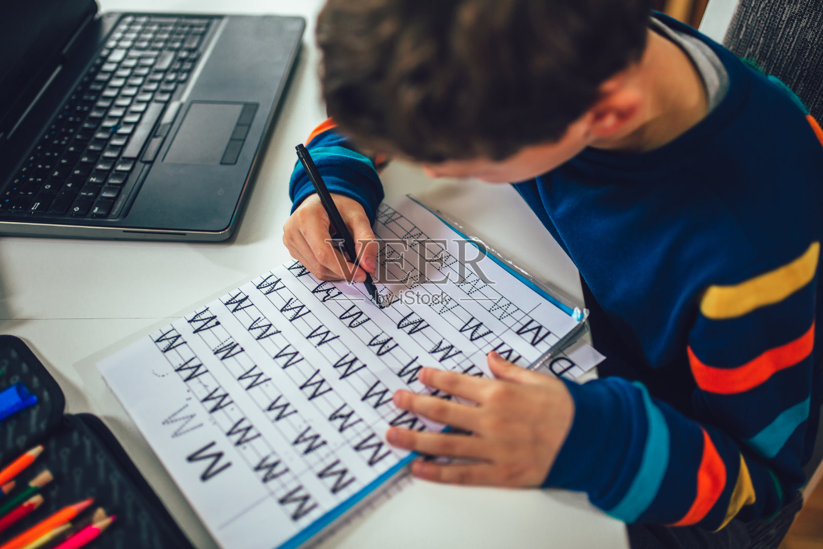 孩子在家练习写作。照片摄影图片