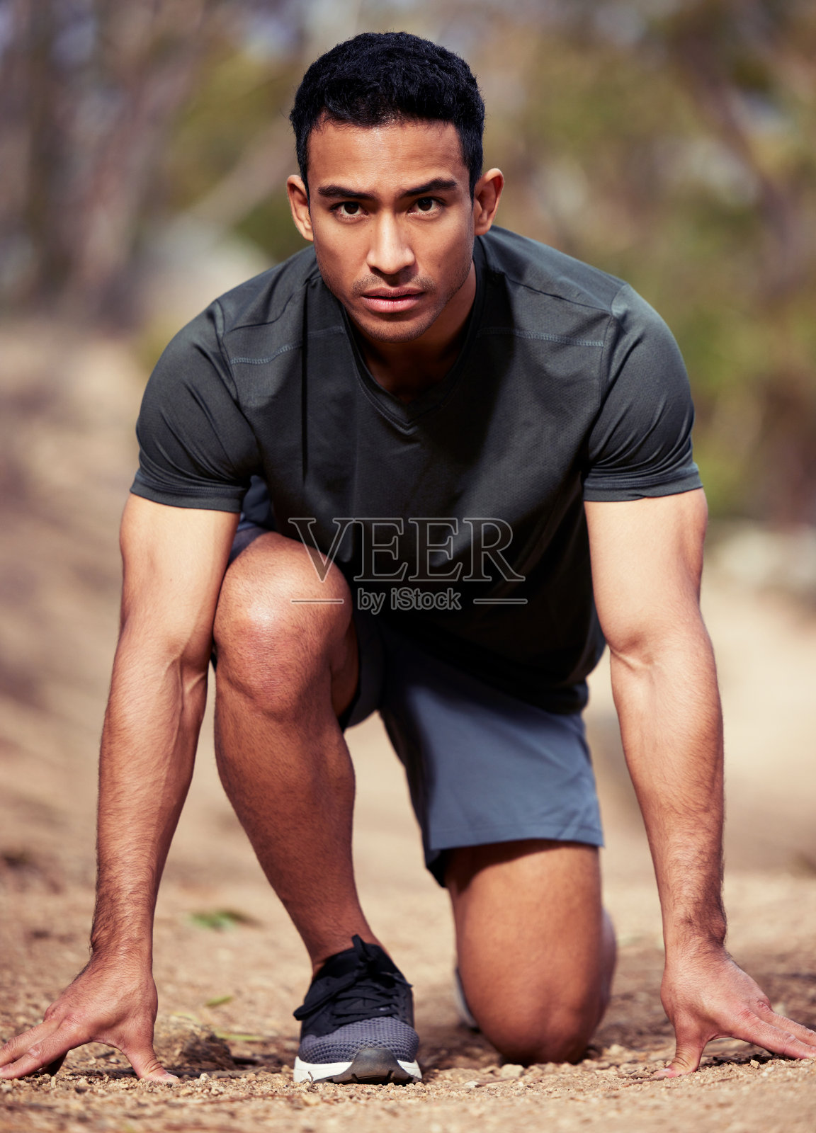 一个运动的年轻人的肖像在开始的位置，而户外锻炼照片摄影图片