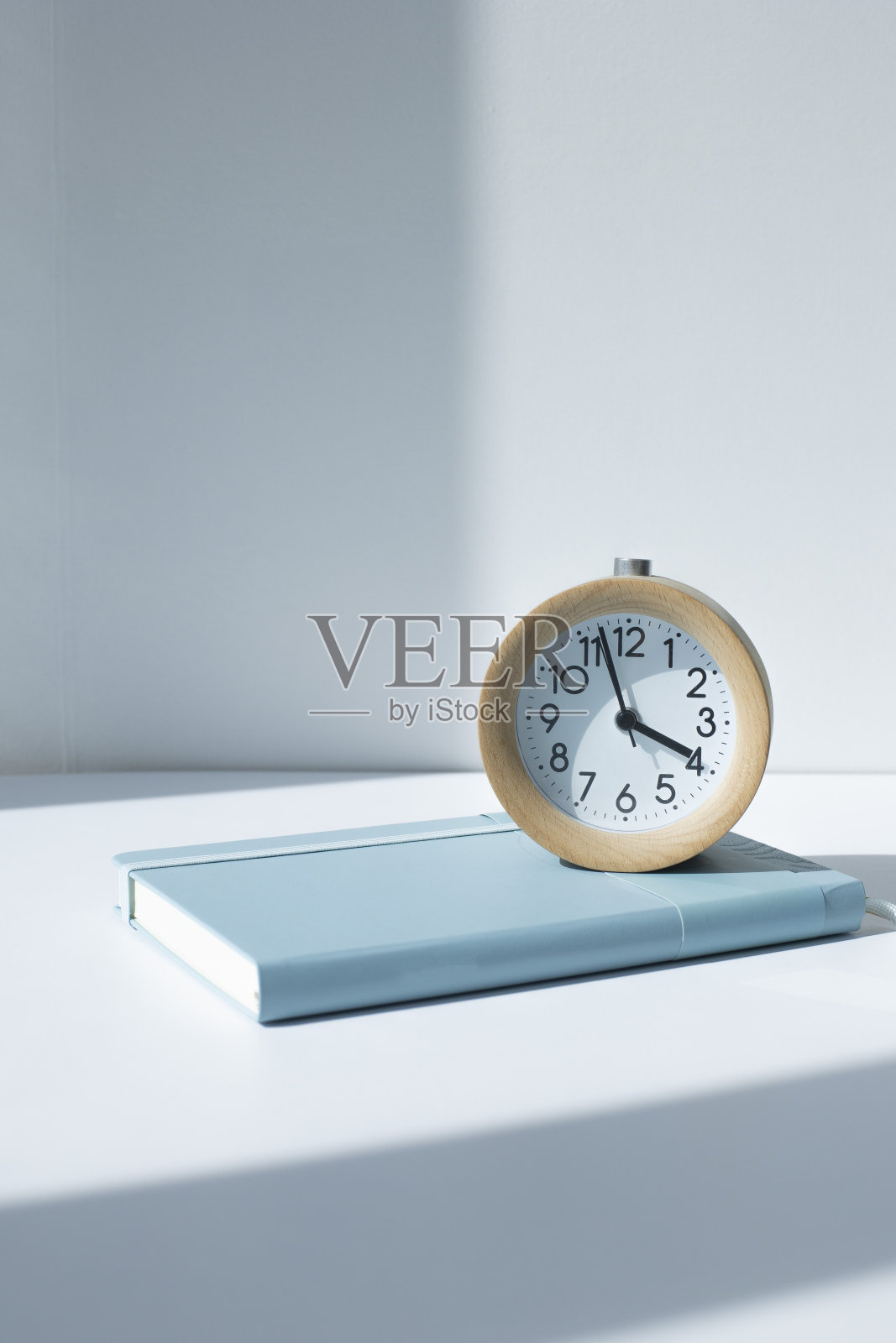 白色背景上的笔记本、日记和闹钟。照片摄影图片