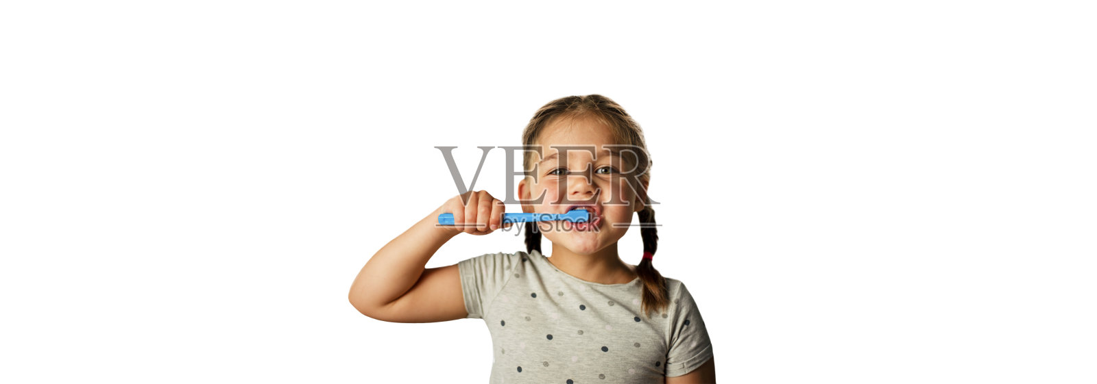 孤立。女孩在白色的背景上用牙刷刷牙照片摄影图片