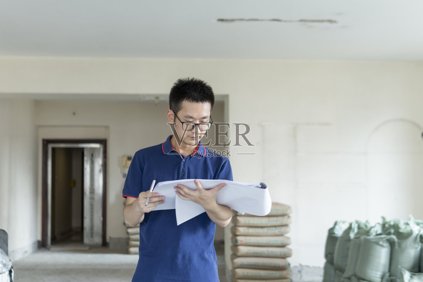 亚洲男性工程师在装修工地处理施工图纸照片摄影图片