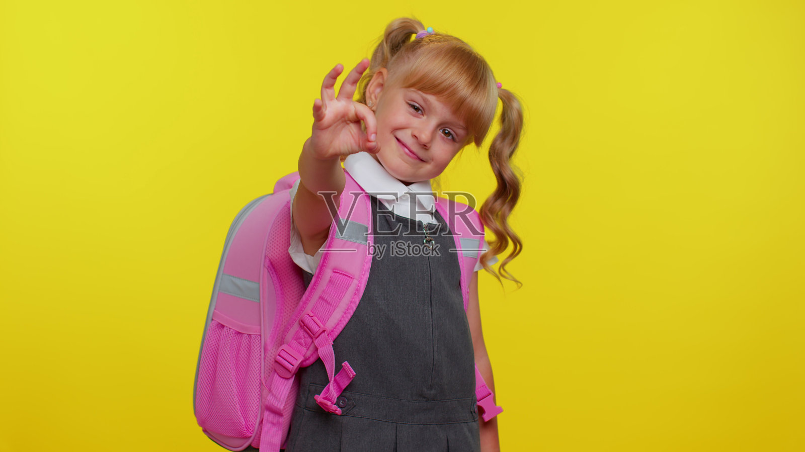 微笑的女学生，赞许地看着相机，露出ok的姿势，好像在暗示肯定的好回答照片摄影图片