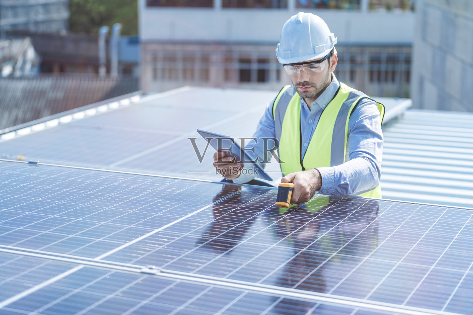 工程师通过电子设备检查太阳能电池板或光伏电池的结构。绿色能源工业可再生能源。在塔顶工作的工人。照片摄影图片