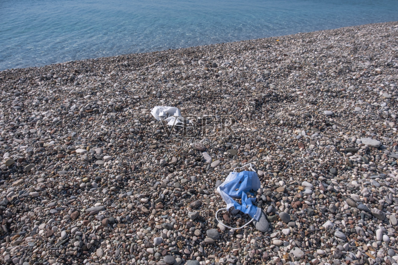 海滩上用过的医用口罩照片摄影图片