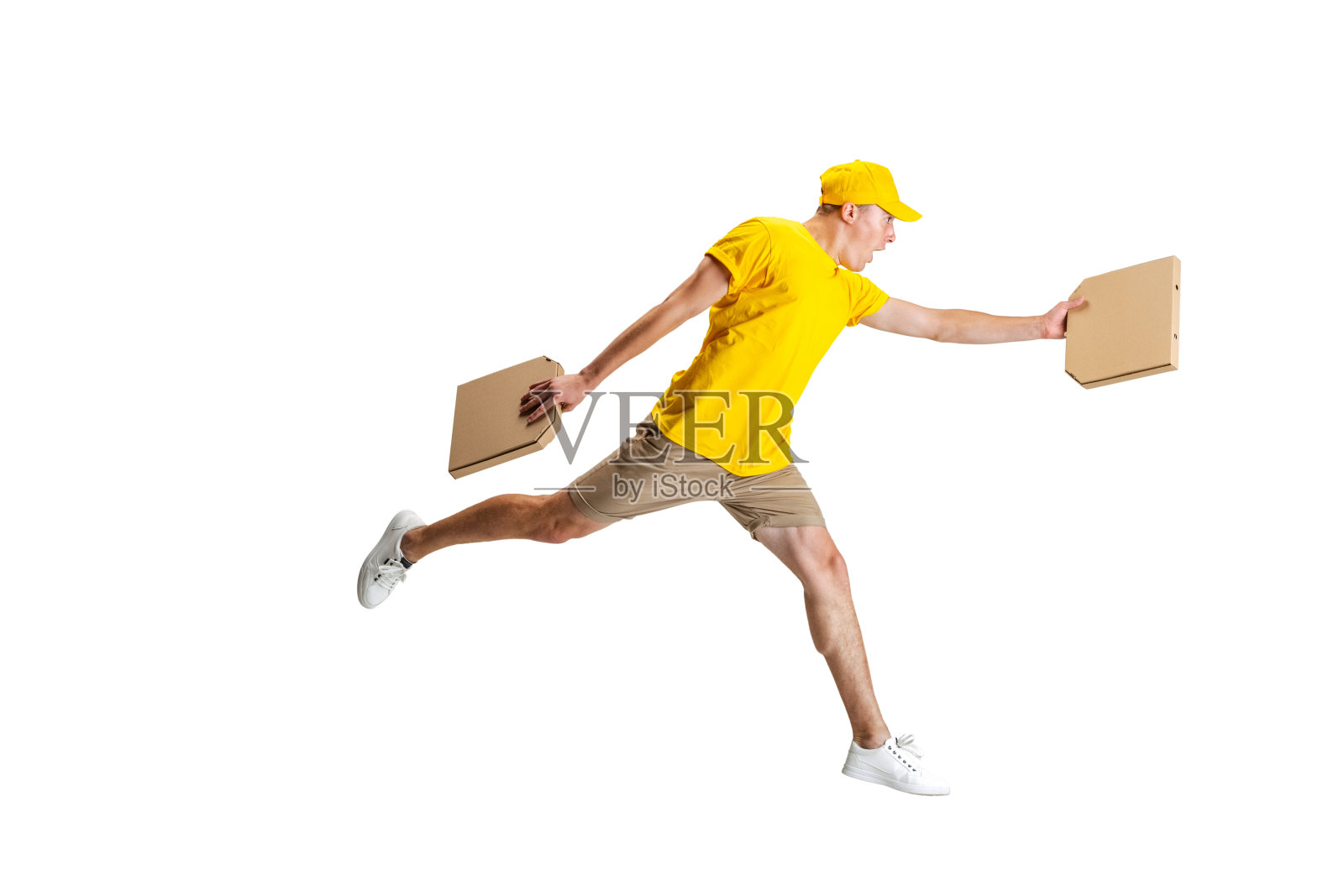 身着黄色制服的年轻快递员在白色背景下跑着送餐。方便、快捷、舒适、安全、服务的理念。照片摄影图片