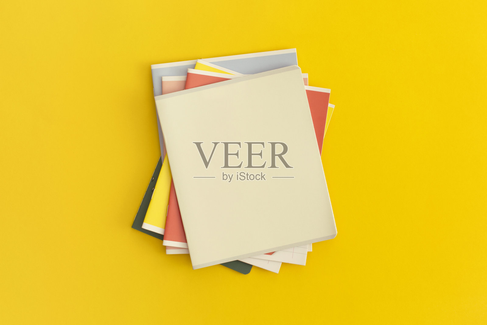 黄色背景的笔记本。前视图。平的。回到学校的概念。照片摄影图片