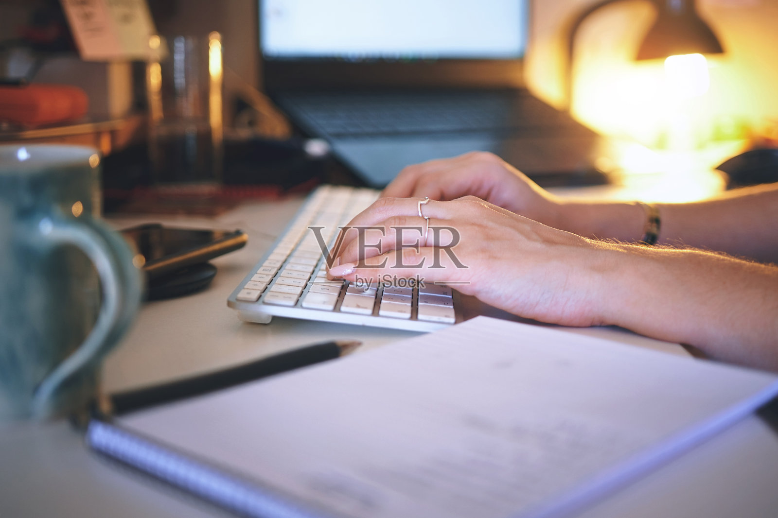 一个不知名的女人独自坐在家里，用电脑工作照片摄影图片