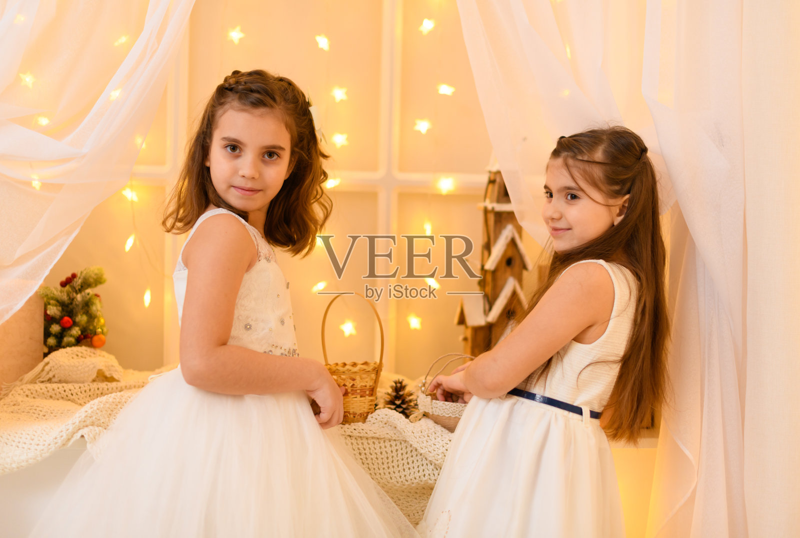 一个小女孩的肖像在家里装饰着节日灯和礼物照片摄影图片