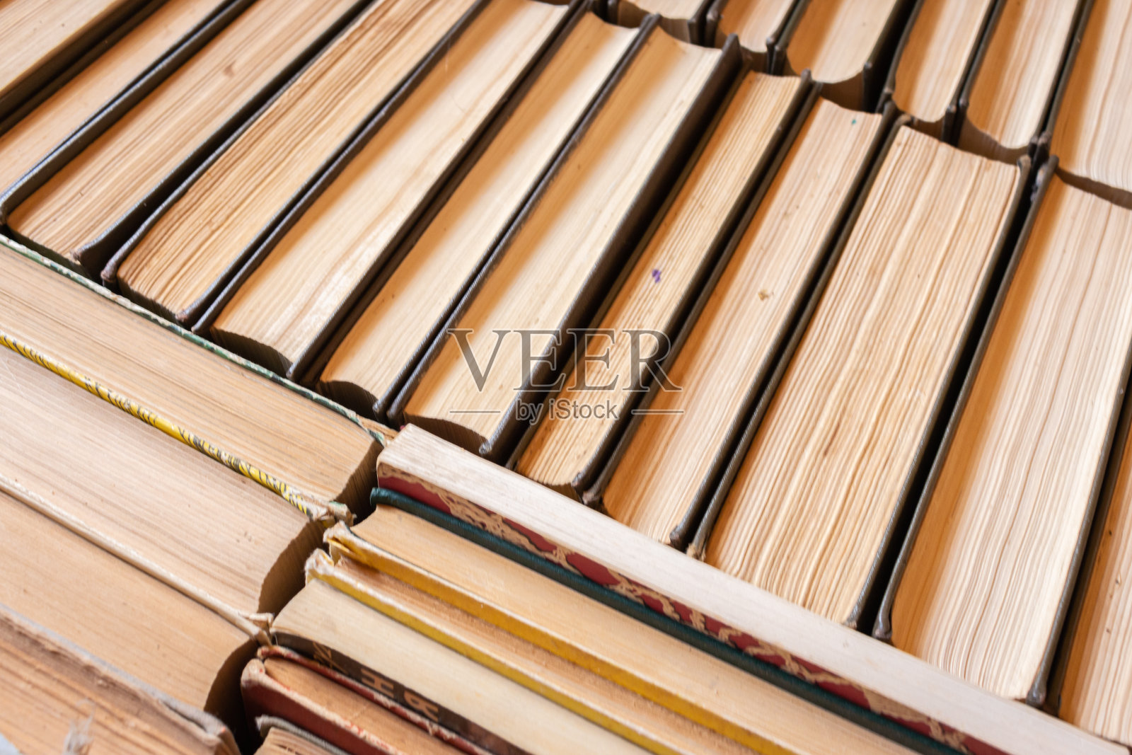 一堆旧书。一堆古董书。文学与学校观念。图书馆的概念。书架靠近。书的背景。教育的概念。知识和智慧的概念。照片摄影图片